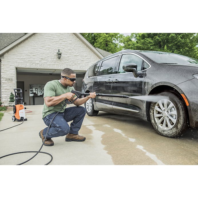 Man kneeling washing van with the STIHL® RE 110 PLUS power washer