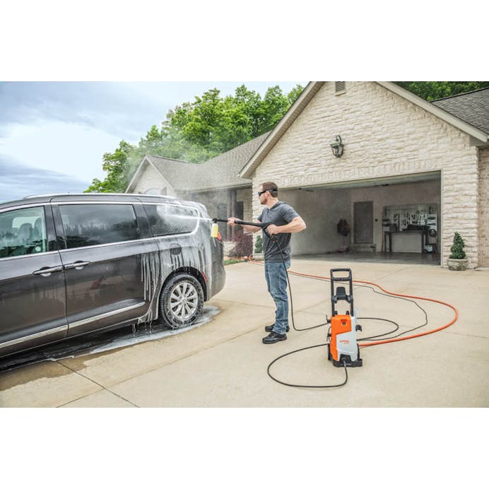 Man using STIHL® RE 110 PLUS to wash minivan