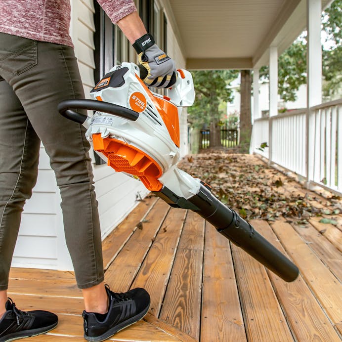 Woman using Stihl Battery-Powered leaf blower on deck