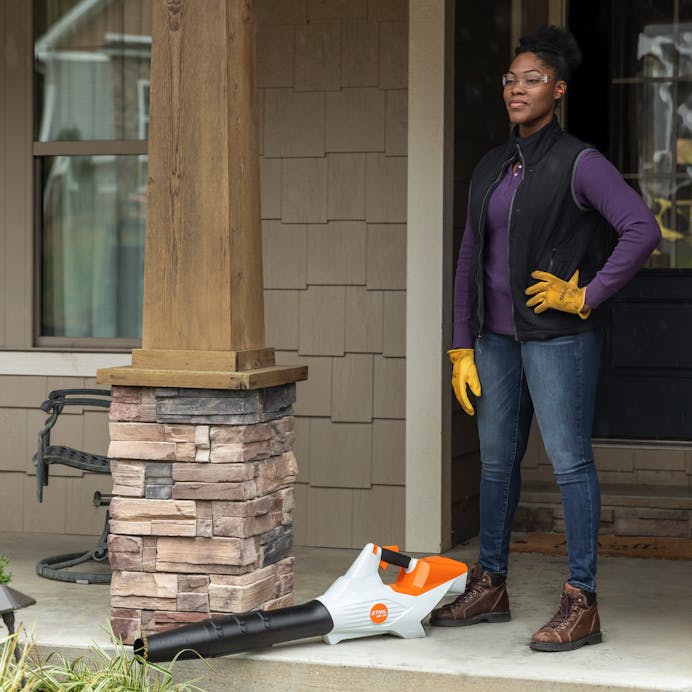 Woman standing on porch with Stihl Cordless Leaf Blower at her feet