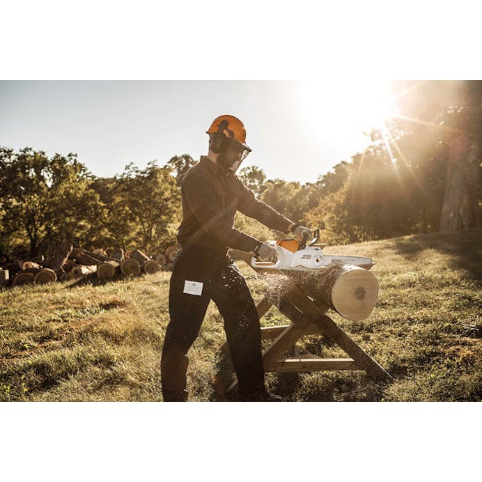 Man cutting log with the Stihl MSA 60 Cordless Chainsaw